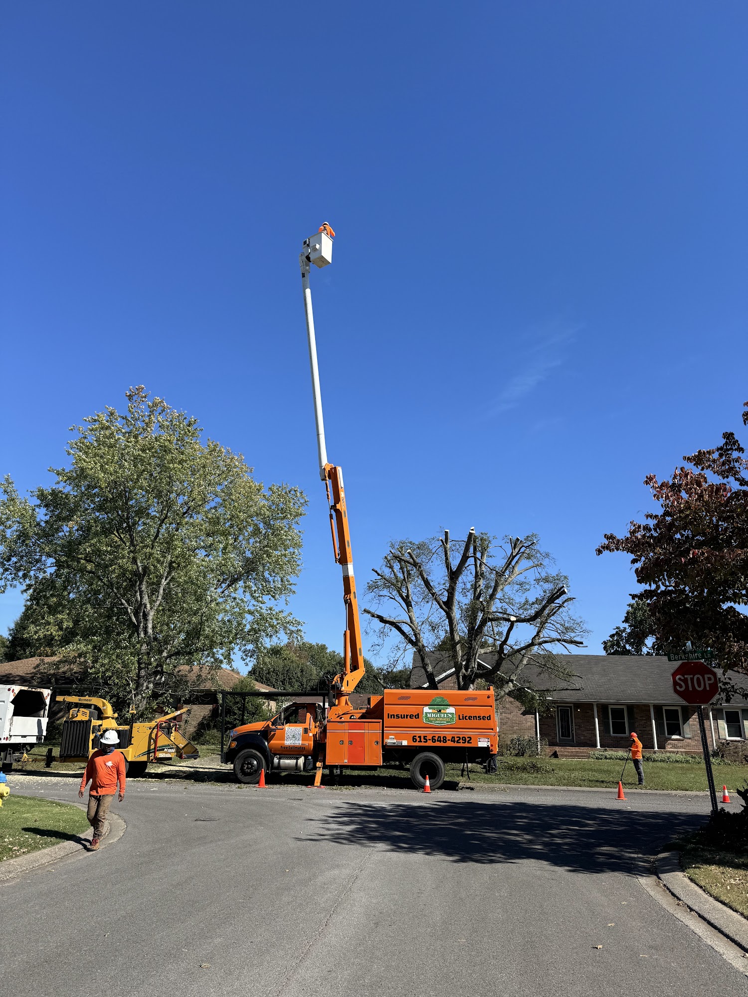 Crew and orange bucket truck working on a residential street